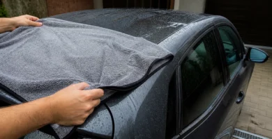 Toalla de microfibra secando el techo mojado de un coche